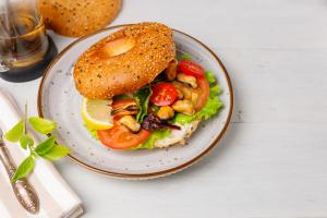 Open faced bagel with cream cheese and vegetables